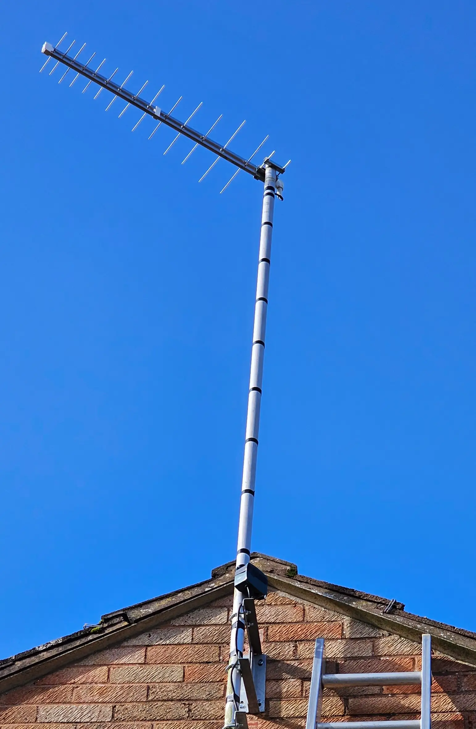 aerial pole Aerial installation technician mounting a satellite dish on a rooftop in Torbay