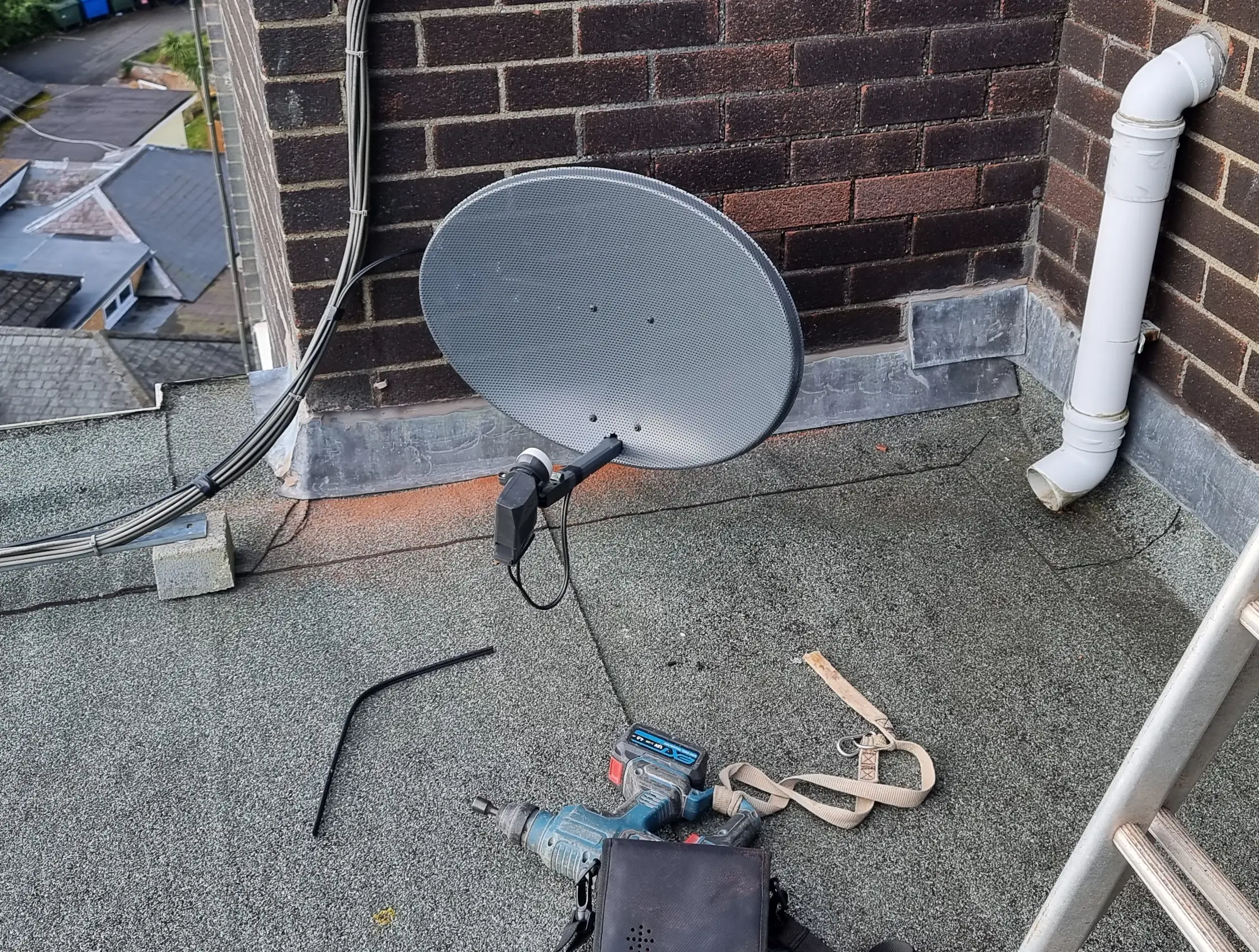 satellite dish engineer torquay Technician securing a satellite dish on a chimney for Sky or Freesat installation in South Devon