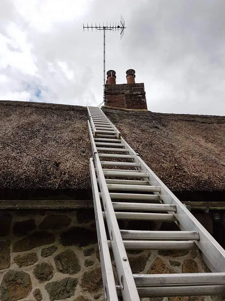 thatched roof aerial Professional aerial repair technician fixing an antenna on a house in Paignton