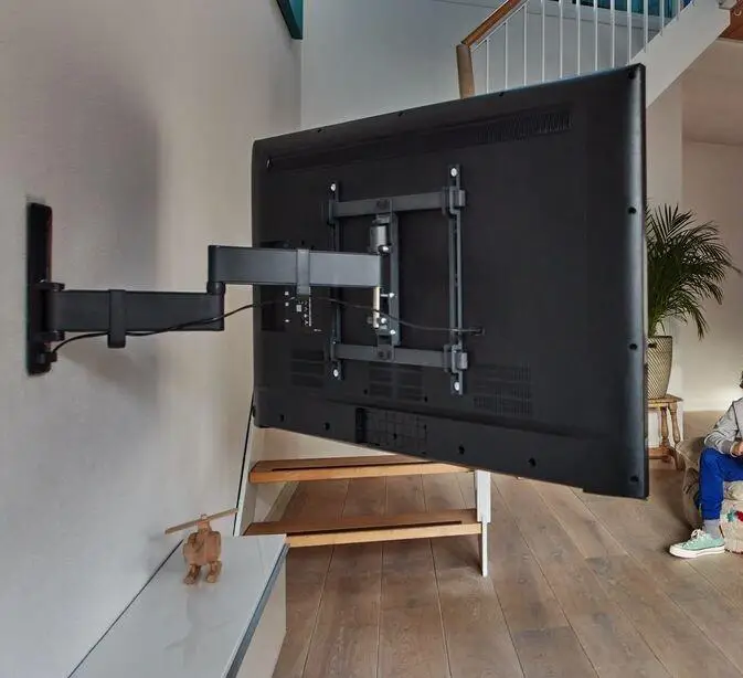cantilever bracket Expert TV wall mounting service in Paignton with the technician securing a large flat-screen TV on the wall