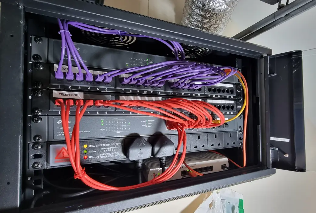 data cabinet Close-up of a data cabinet with neatly organized network equipment, including switches and patch panels, in a commercial building in Brixham