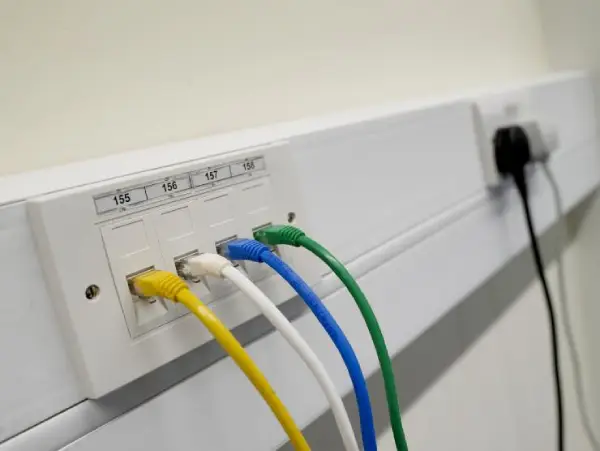 ethernet sockets Close-up of a technician configuring a router and network switches in a data cabinet during a commercial network setup in Torquay